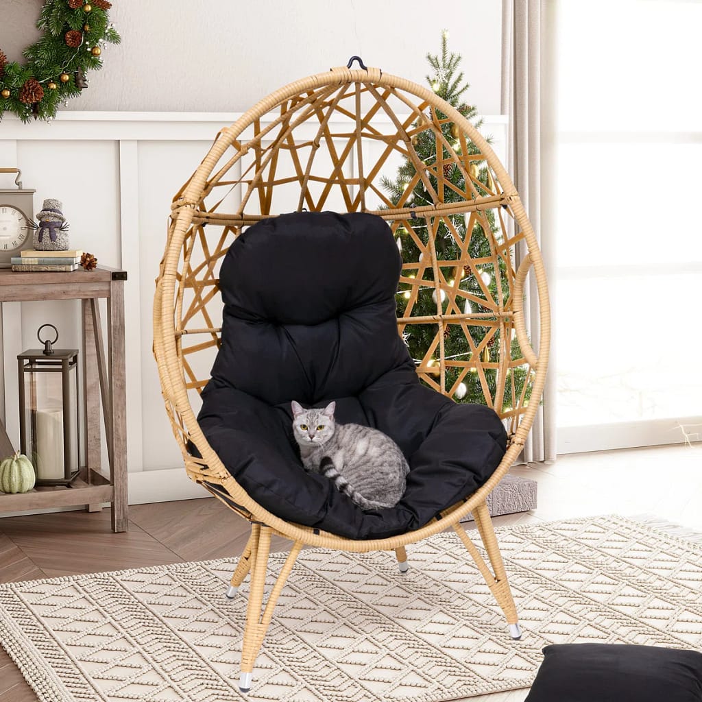 Boho egg-shaped wicker porch swing with foam cushion on a porch